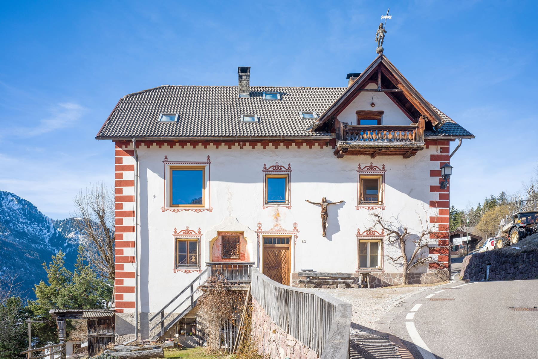 Spätwinterliches Foto des Hauses Lusenberg mit verschneitem Berg im Hintergrund