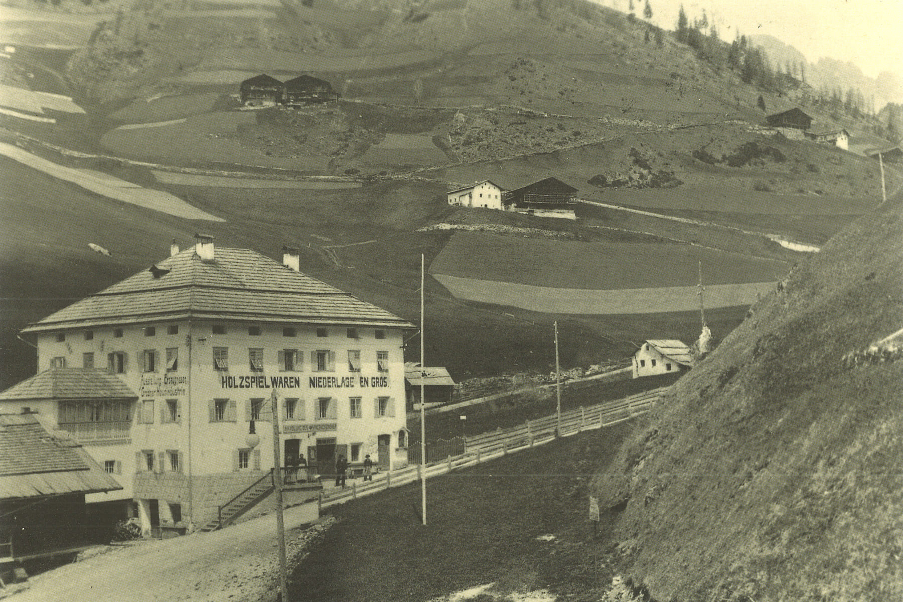 Foto um 1905 des alten Hauses Vastlé der Firma Senoner Vinzenz mit den Bauernhöfen am Steilhang von Plesdinaz
