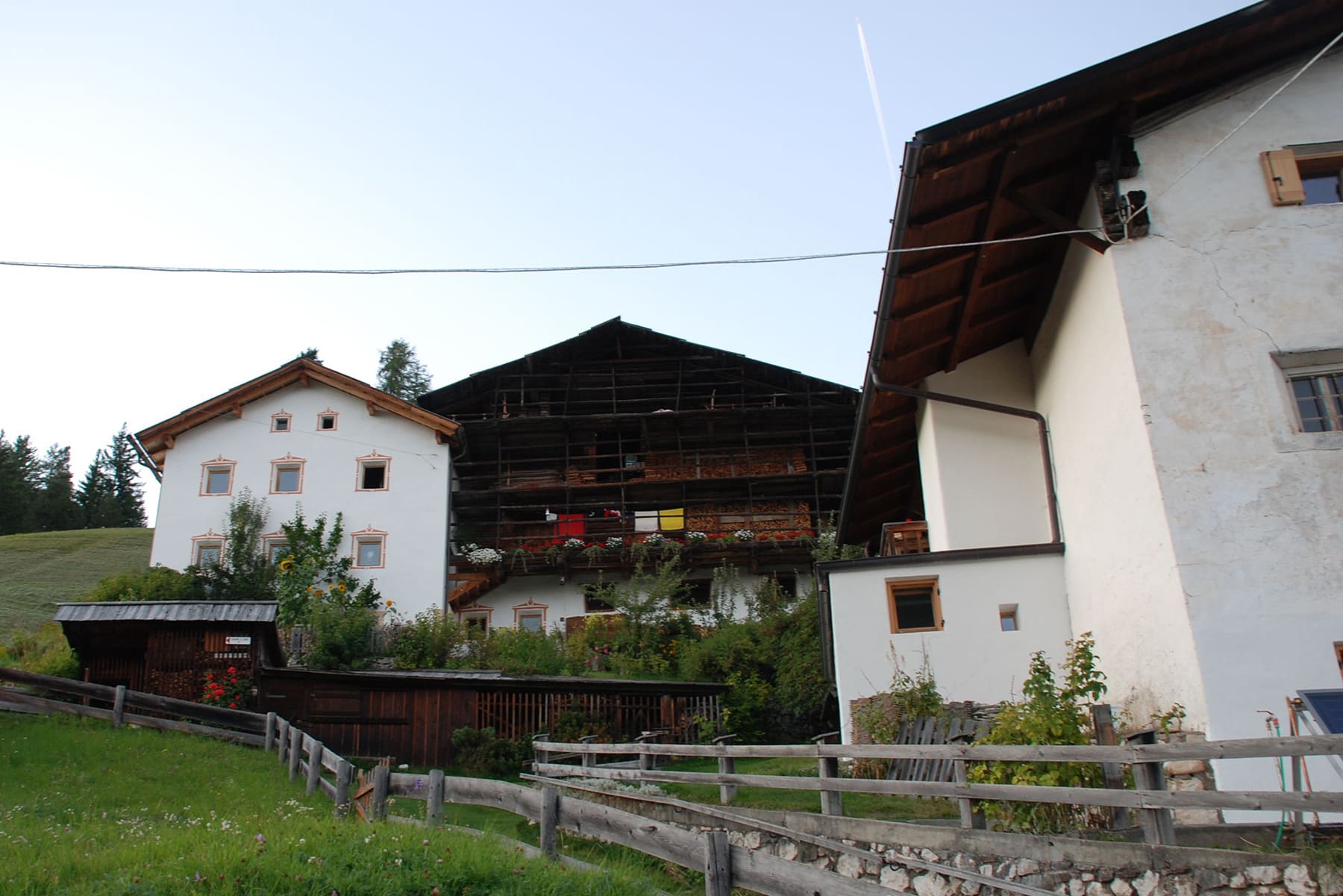 Blick auf Höfe von Ulëta an den steilen Hängen, vom Wald umgeben
