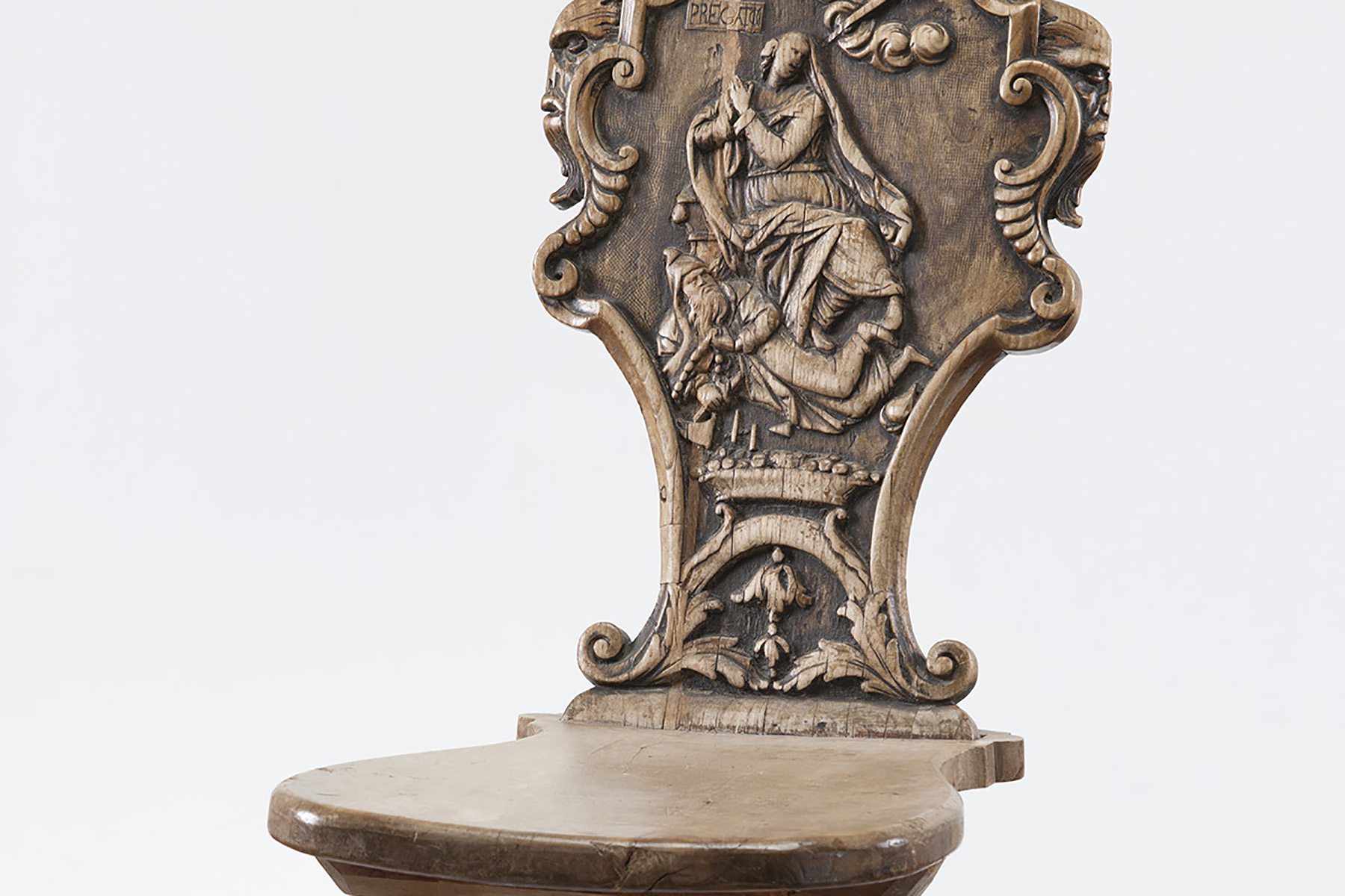 Rückenlehne mit einem geschnitzten Votivbild in der Mitte