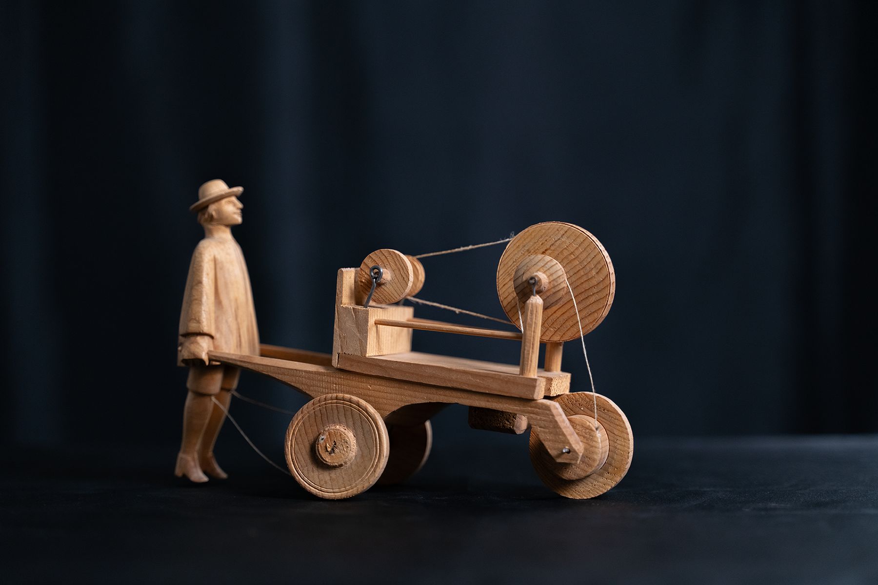 Bewegliches Spielzeug aus Naturholz eines Scherenschleifers, der einen Wagen mit Schleifmaschine führt