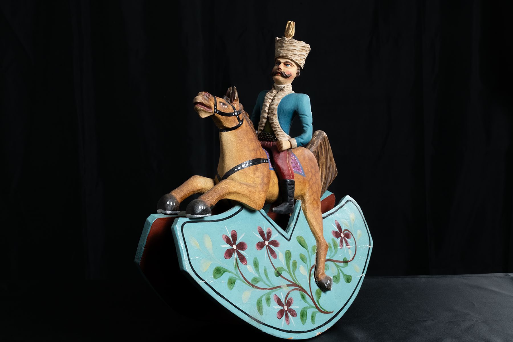 Galoppierendes Pferd auf Wiege mit einem Reiter in Uniform