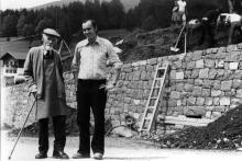 Der hundertjährige Bera Sepl da Stufan (Josef Rifesser) mit dem Archäologen Reimo Lunz bei der neuen Straßenmauer unterhalb des Col de Flam Hofes; dahinter wurde der das erste rätische Haus ausgegraben. 1977
