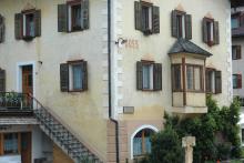 Foto Detailansicht der Fassade von Haus Doss mit der Aufschrift „Doss“ und einem Erker