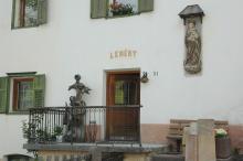Detailfoto der Fassade mit Marienstatue und Skulptur auf der Terasse vor der Eingangstür