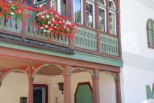 Detailansicht Holzveranda mit Blumen und darunterliegendem Eingangsbereich, 2006