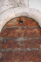 Rundbogige Haustür des Wohnhauses Janon mit eingemeißelter Schere und Nadel am Schlussstein