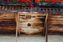 Die Jahre haben sichtbare Spuren am Holzbalkon vom Hof Crëpa hinterlassen.