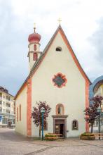 Die Sankt-Anton-Kirche steht in der Mitte des Antoniusplatzes von St. Ulrich.