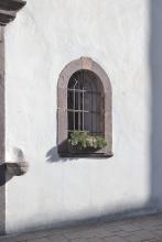 Vergittertes Fenster rechts neben dem Hauptportal der Kirche Sankt Anton in Boden.