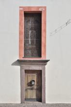 Bemalte Glasfenster, höher als der Nebeneingang, bringen Licht in die St.-Anton-Kirche.