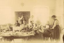 Schülerinnen und Schüler beim Schnitzunterricht mit Lehrer Albino Pitscheider; Fotoaufnahme 1911