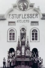 Verleger Ferdinand Stuflesser mit Ehefrau und Mitarbeitern beim aufgestellten Altar vor dem Atelier zu Petlin, vor 1914