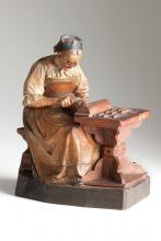 Geschnitztes und gefasstes Selbstbildnis der Katharina  Kasslatter an einem kleinen Schnitztisch, konzentriert auf ihre handwerkliche Tätigkeit