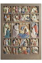 Geschnitzte, bemalte und in einen Holzrahmen eingesetzte Szenen aus der Weihnachtsgeschichte, im Zentrum die Heilige Familie im Stall