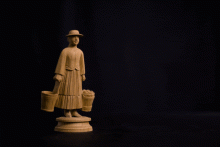 Spielzeug einer Eimerträgerin, bei der sich der gesamte Körper durch eine Pendelmechanik nach vorne und hinten bewegt