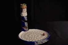 Beim „Kakelorum” wird die Kugel durch eine ausgehöhlte Figur eingeworfen und landet im Teller mit nummerierten Vertiefungen an der Basis.