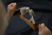 Ziehspielzeug mit den Figuren zweier Böcke, die sich mit Hilfe zweier gekreuzter Schienen bewegen und die Köpfe aneinanderschlagen