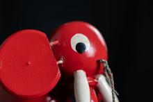 Kopf eines hölzernen, rot bemalten Spielzeug-Elefanten