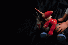 Pinocchio auf einem Esel mit vier Rädern, der sich beim Schieben auf  und ab bewegt