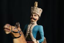 Geschnitzter und bemalter Reiter in blauer Jacke mit turbanähnlicher Kopfbedeckung 