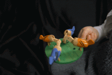 Spielzeug in Form von vier Hühnern, die beim Schwingen des Pendels ihre Köpfe bewegen als würden sie Futter vom Boden aufpicken