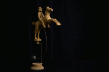 Balancierender Reiter aus Naturholz, der mit Hilfe des Bleigewichts auf dem Podest gehalten wird